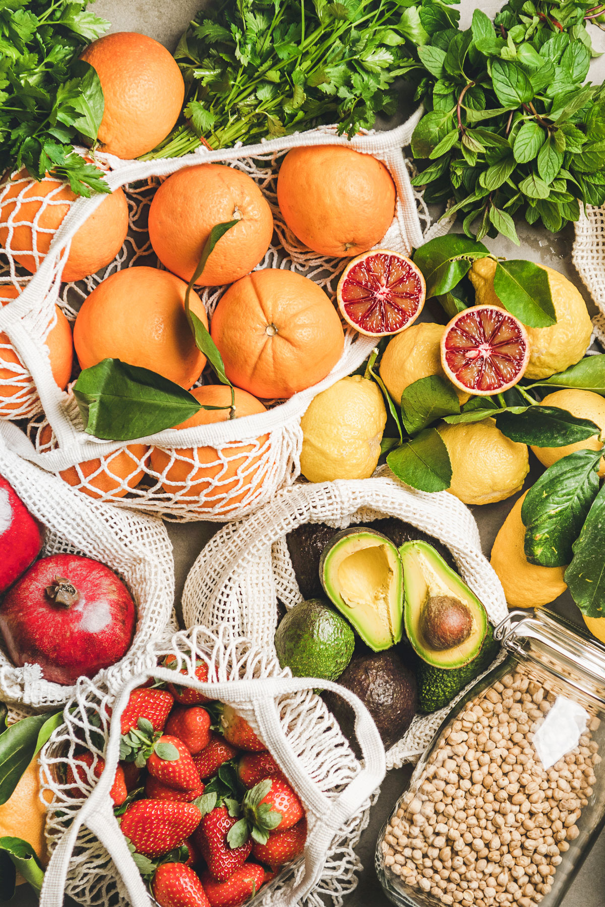 Flat-lay of fruit, vegetables, nut, greens and essential products.