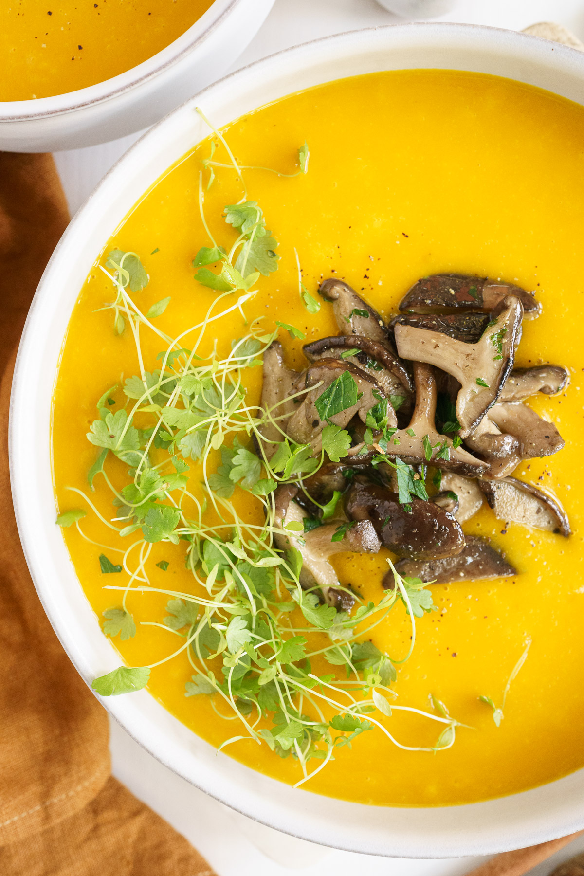 Top view closeup of pumpkin soup top with mushroom and parsley