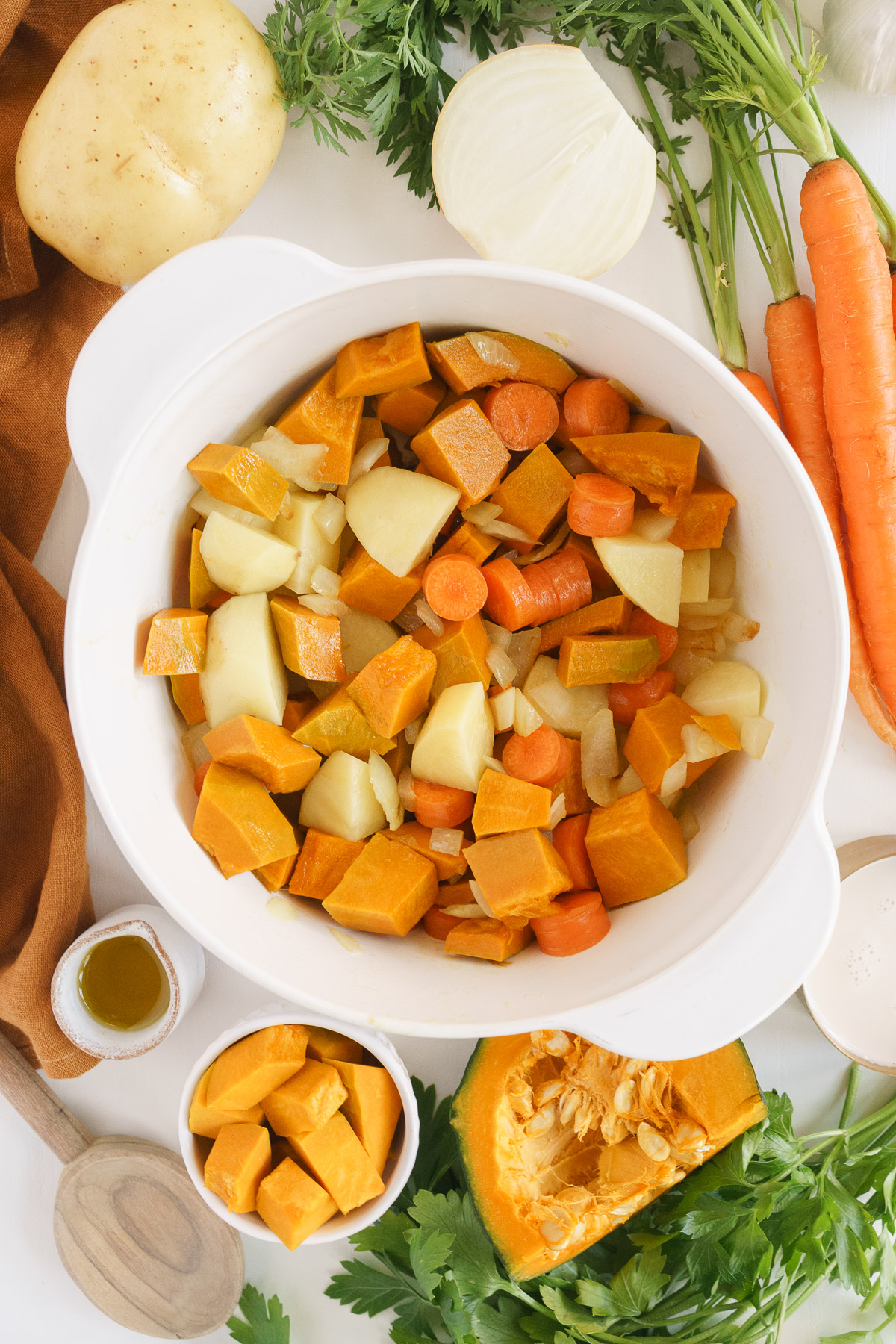 top view of main ingredients including pumpkins, carrots, and potatoes in a pot