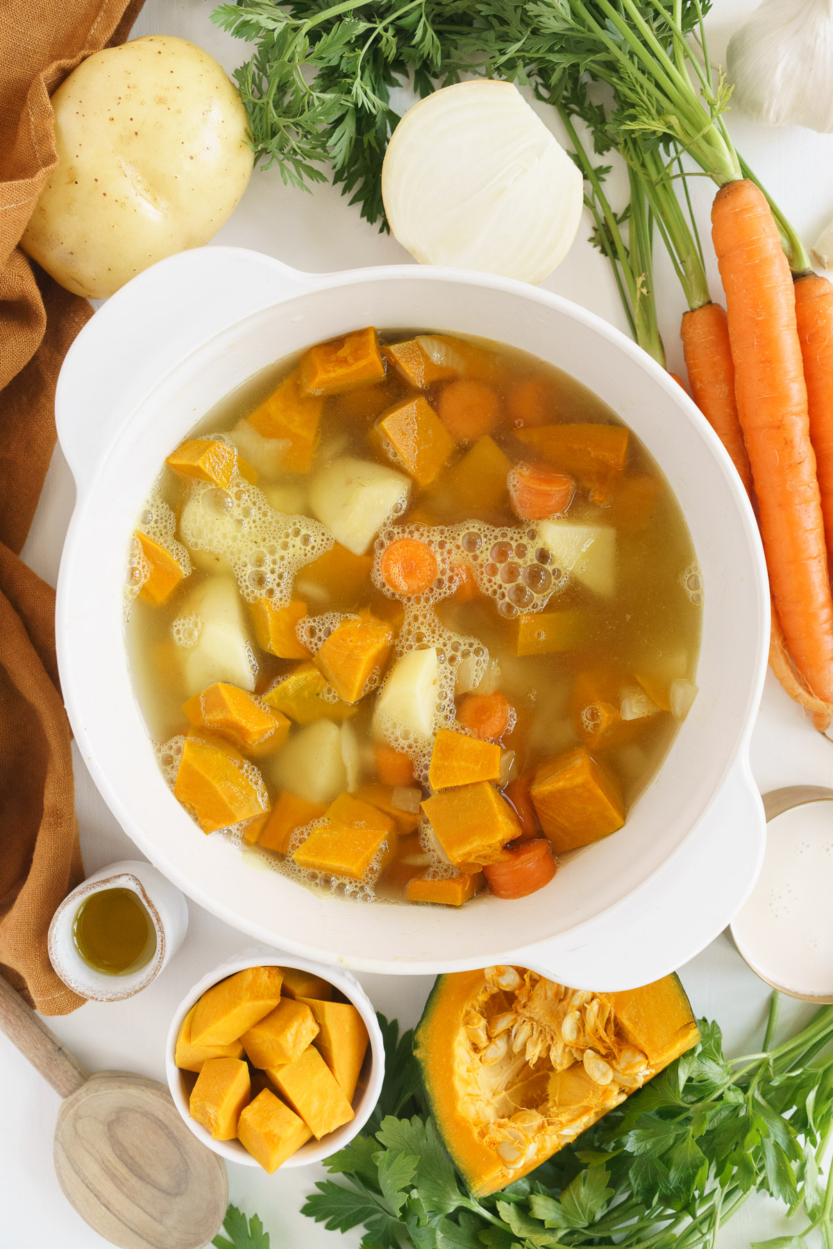 top view of simmering pumpkins, carrots, and potatoes