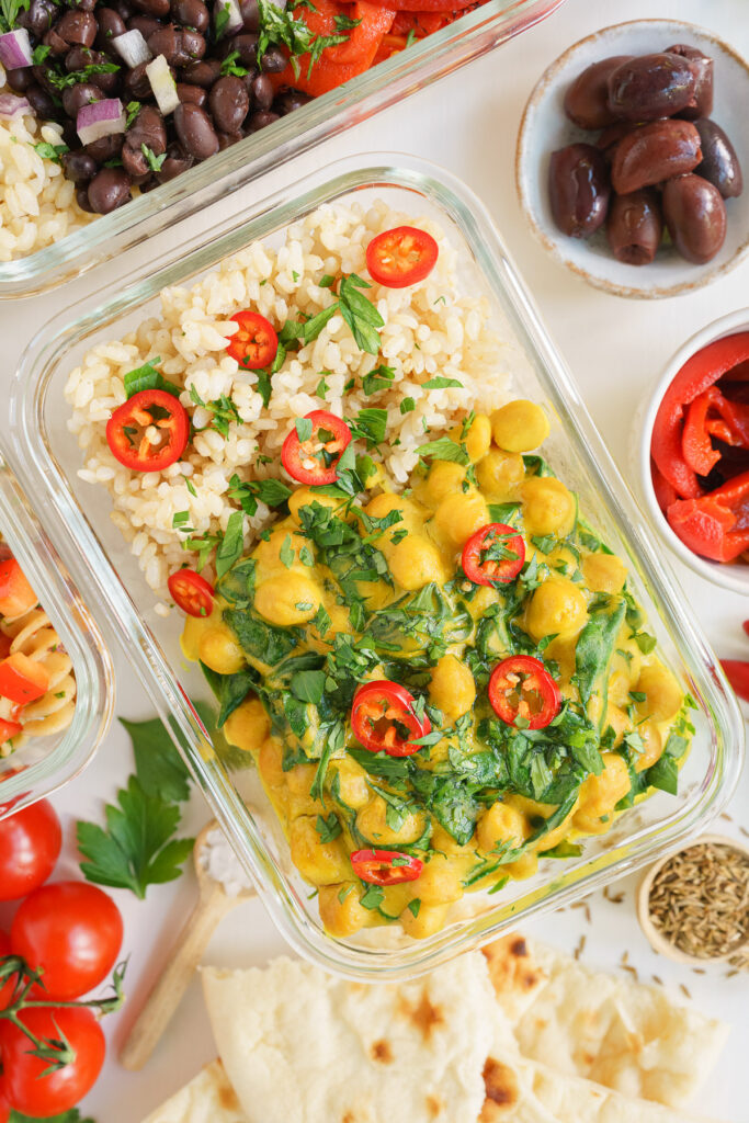 Vegan meal prep bowl on the table with chickpea curry to take for lunch.