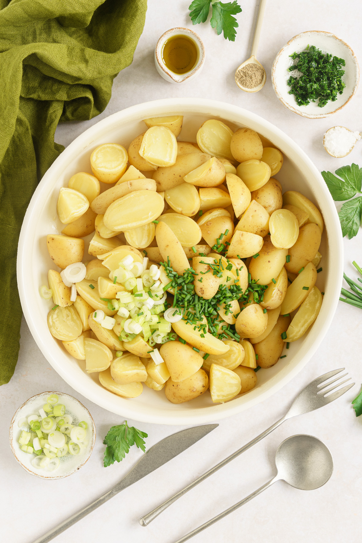 cooked potatoes in a bowl with green onions
