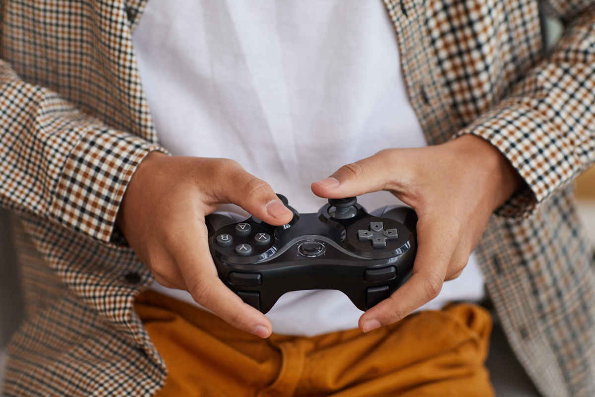 Teenager hands holding a controller playing videogames