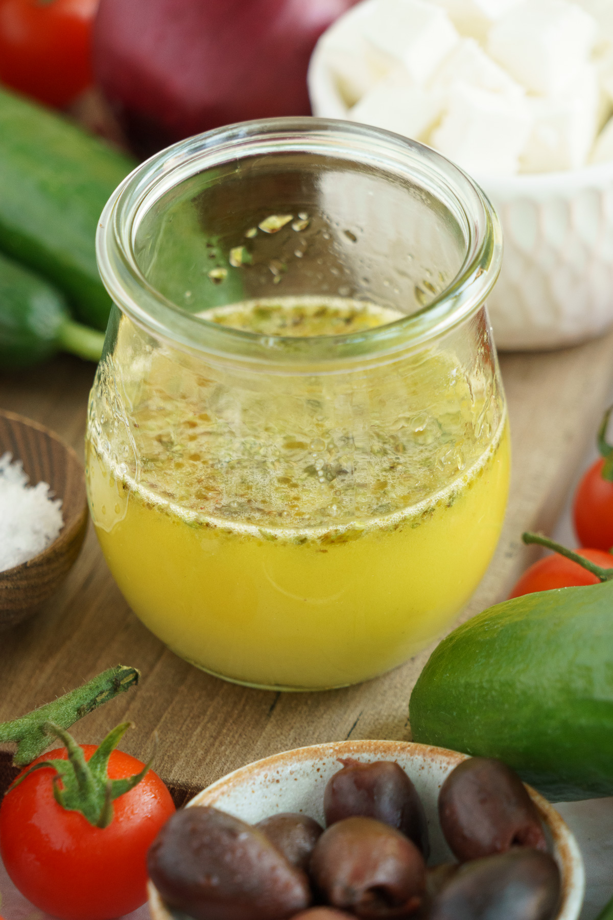 A mason jar with a creamy and smooth dressing mixture of lemon juice, olive oil, oregano, salt, and pepper.