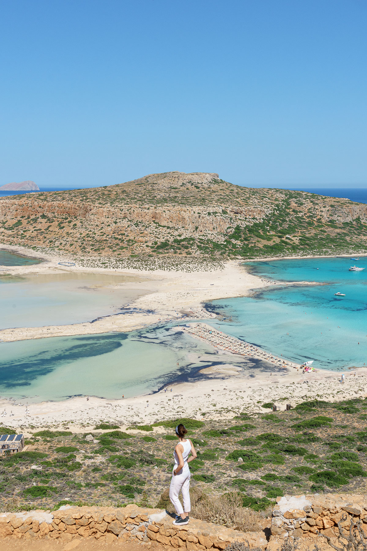 Woman looking towards the horizon in Crete with a wonderful beach in the background