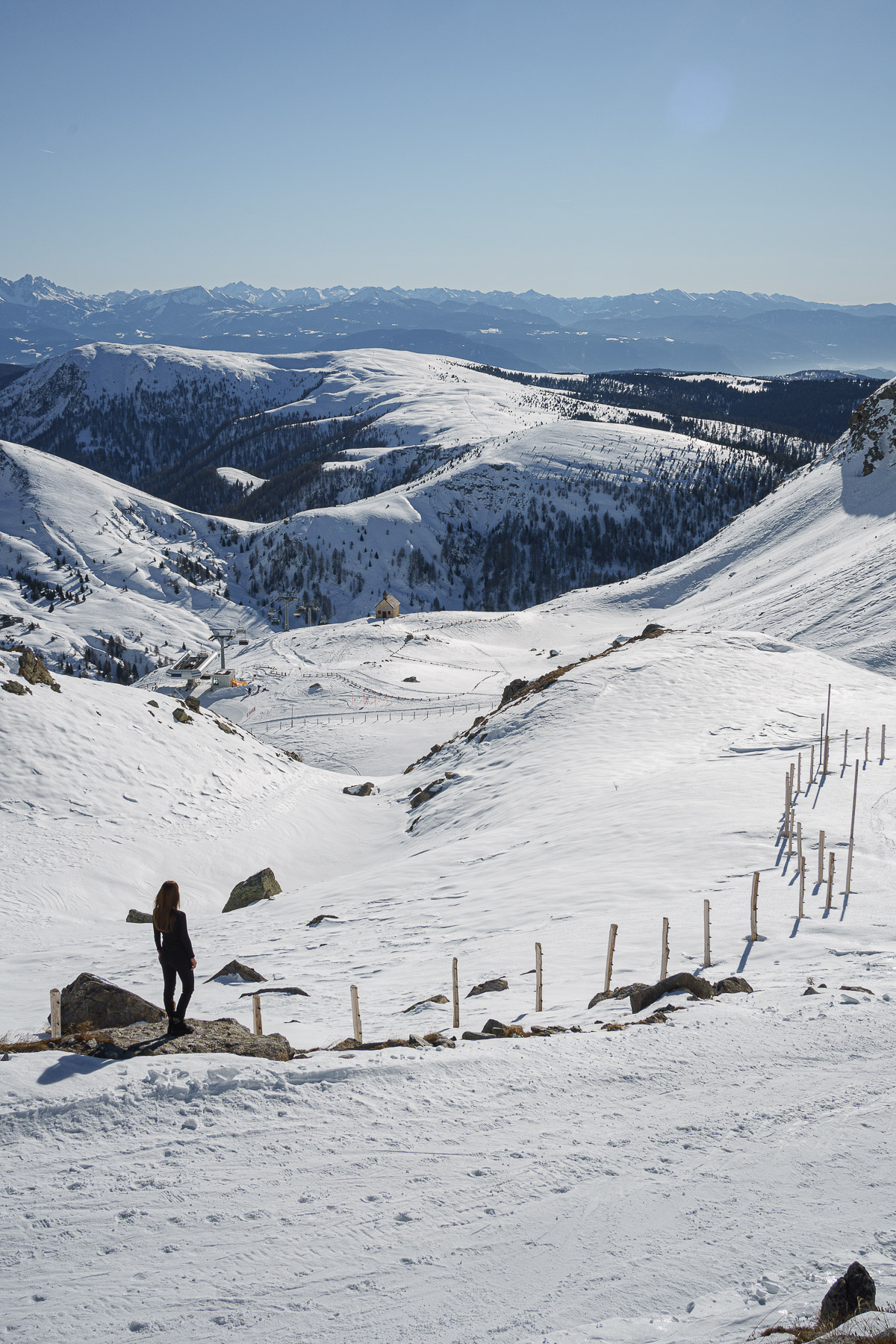 Woman looking at the panorama in the snowy mountains in wintertime