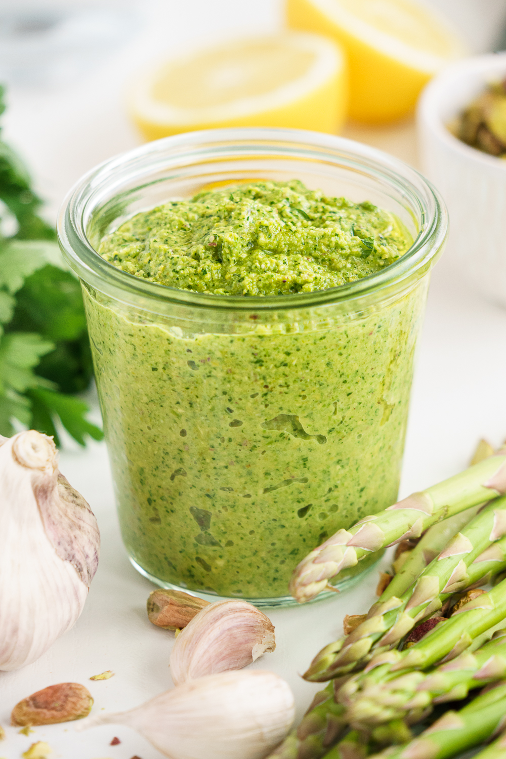 Glass container filled with fresh asparagus pesto
