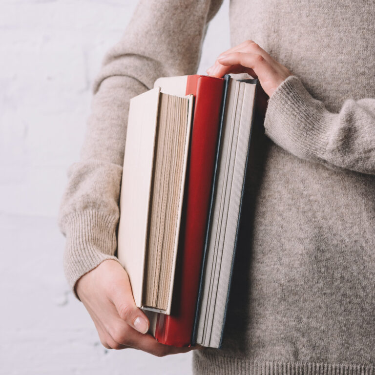 Woman holding financial literacy books in her hands