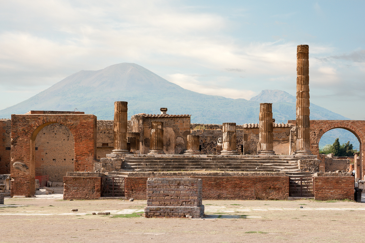 Ancient ruins of Pompei with volcano Vesuvius at back during sunset, Italy