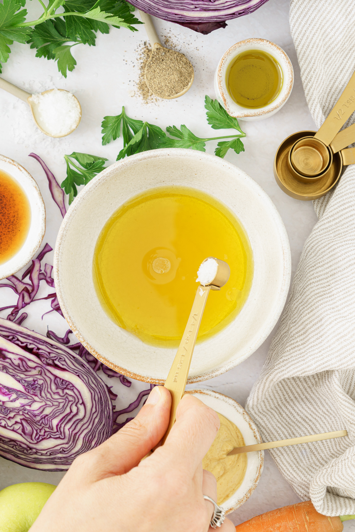 an image of a hand adding a salt to a bowl with olive oil