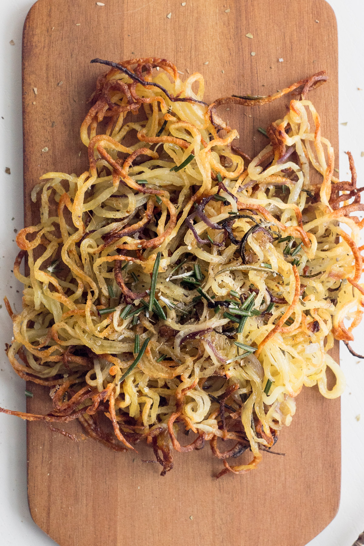 Top down view of spiralized potatoes on a wood board