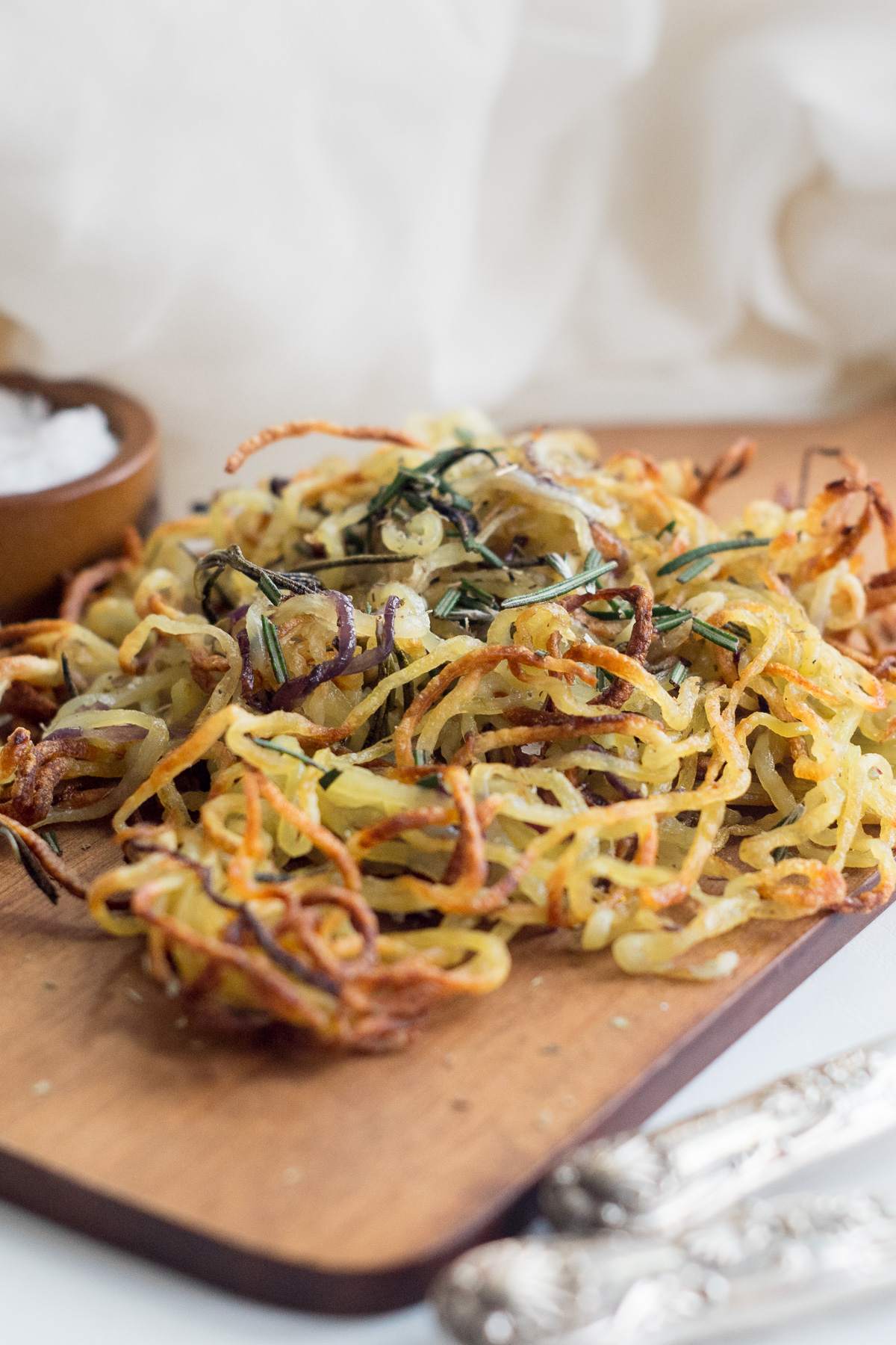 Three quarter view  of spiralized potatoes on a wood board