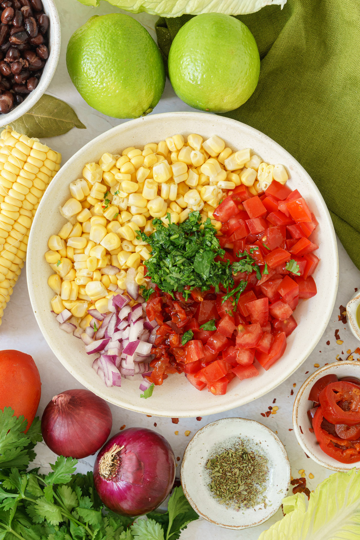 top image of a bowl full of corns, tomatoes, cilantro and onions