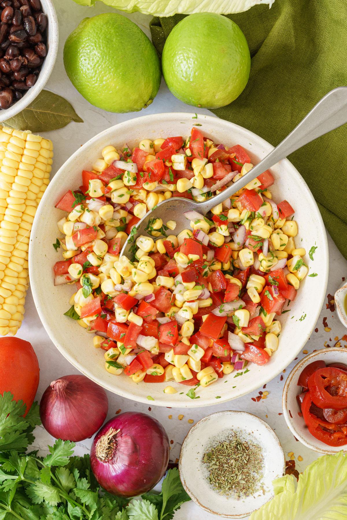 top image of a bowl with combined corns, tomatoes, cilantro, onions