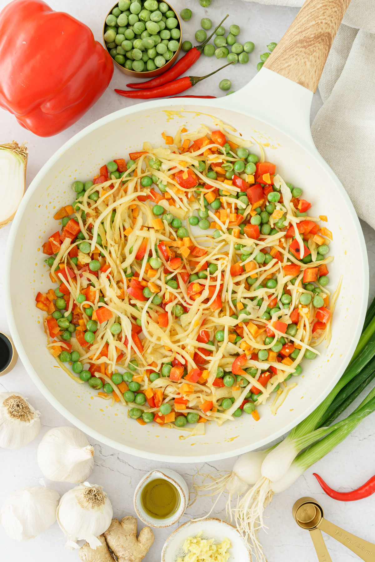 top image of a pan with diced carrots, diced pepper, shredded cabbage and green peas