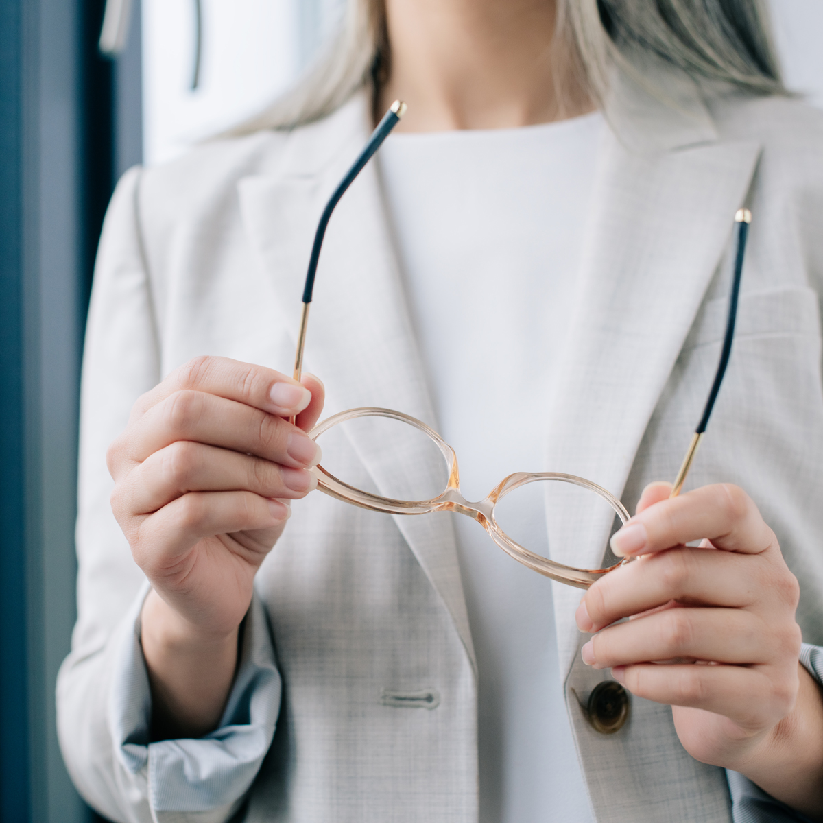 image of a woman holding eyeglasses