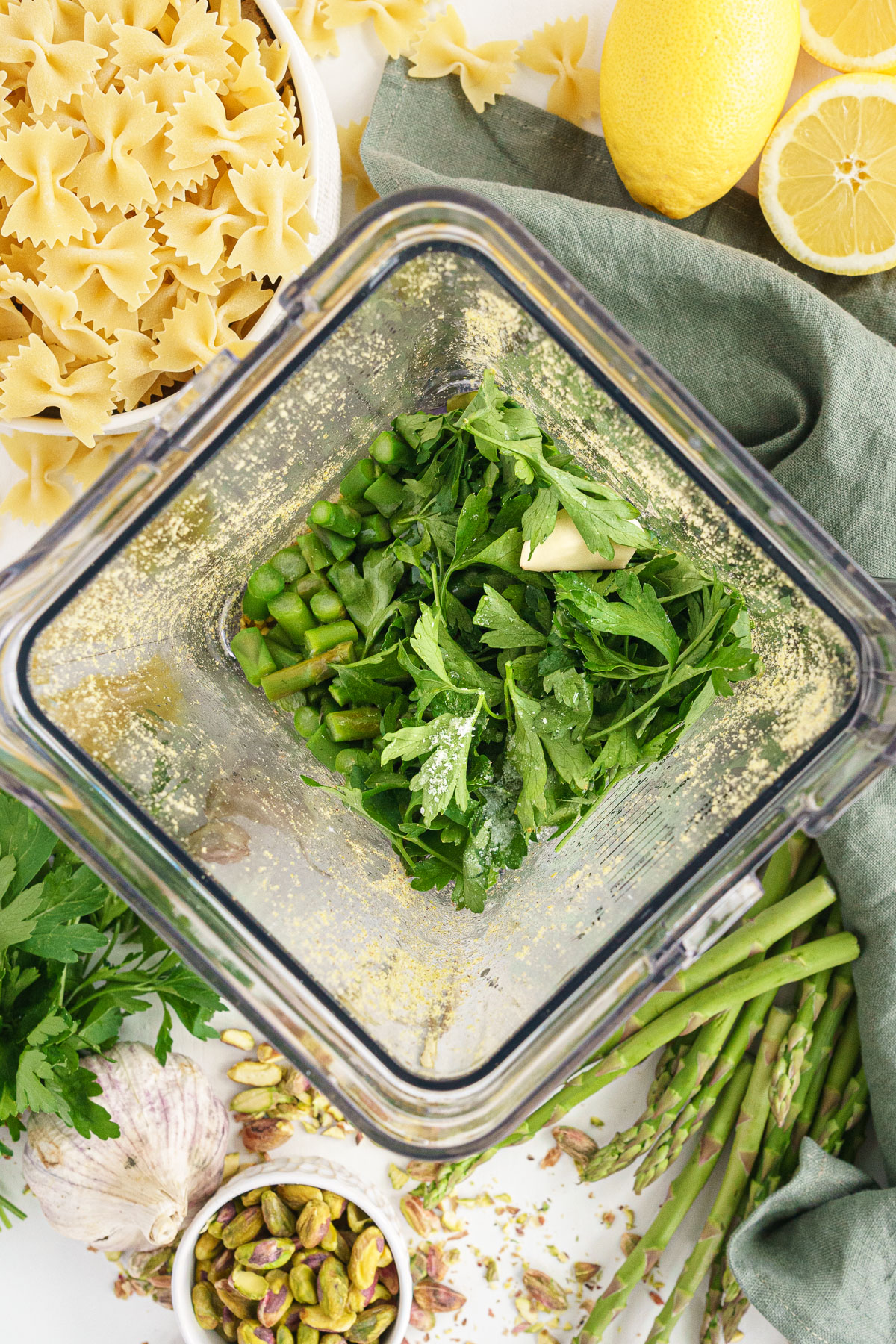 Blender with all ingredients to make asparagus pesto