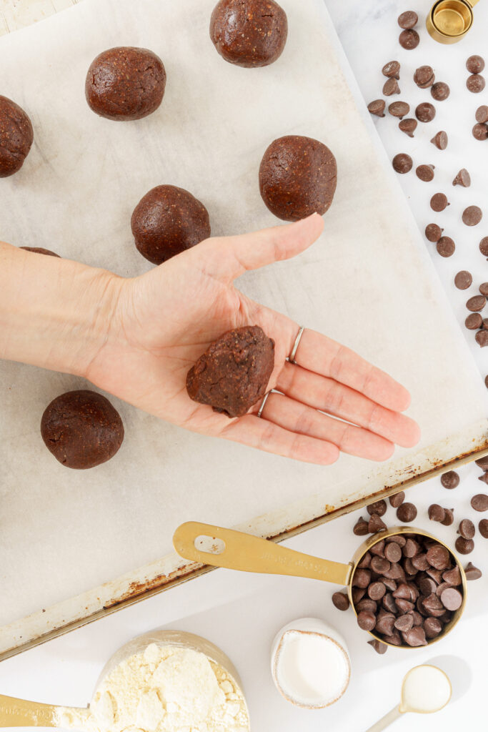 top-down view of an open hand holding a scoop of cookie dough