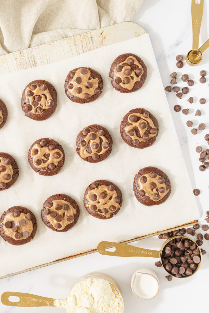 top down view image of cookies with chocolate chips toppings arranged in a neat pattern, ready to be baked