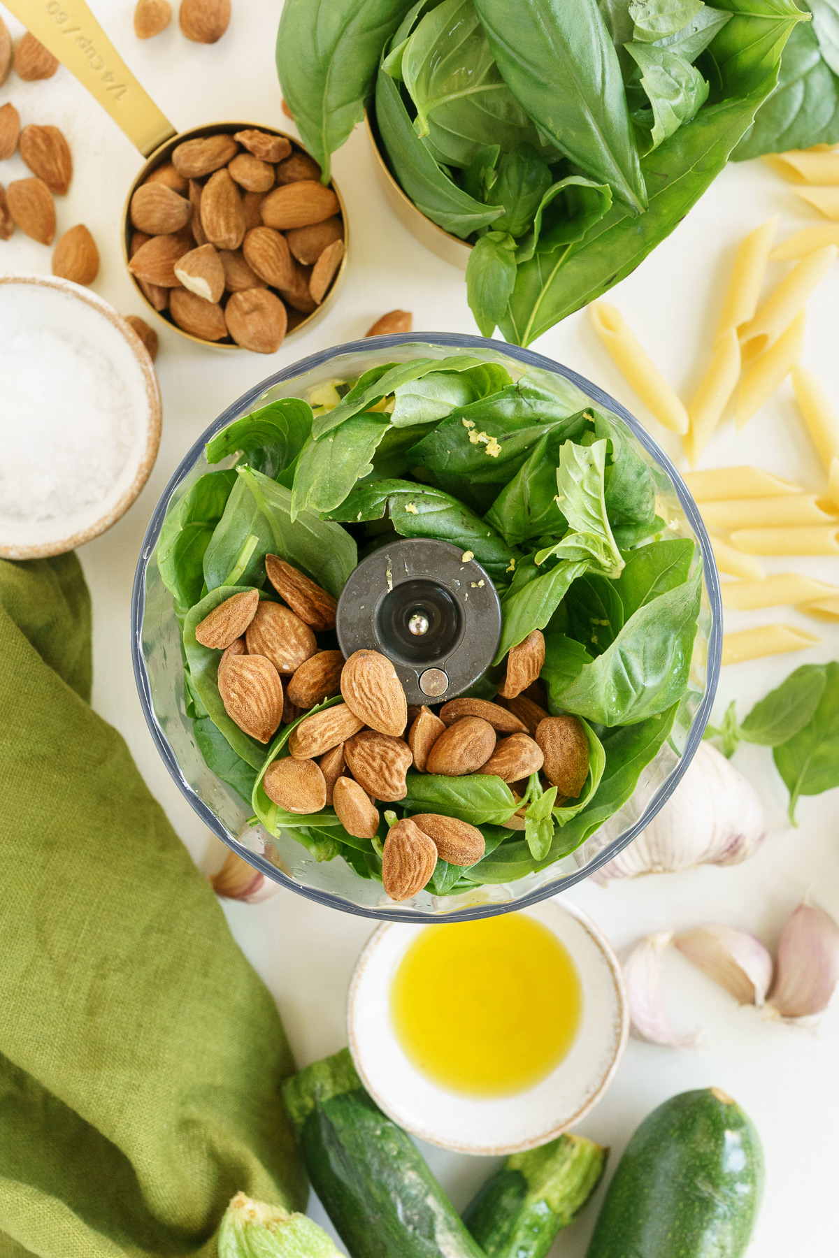 Ingredients to make the pesto in a food processor bowl.