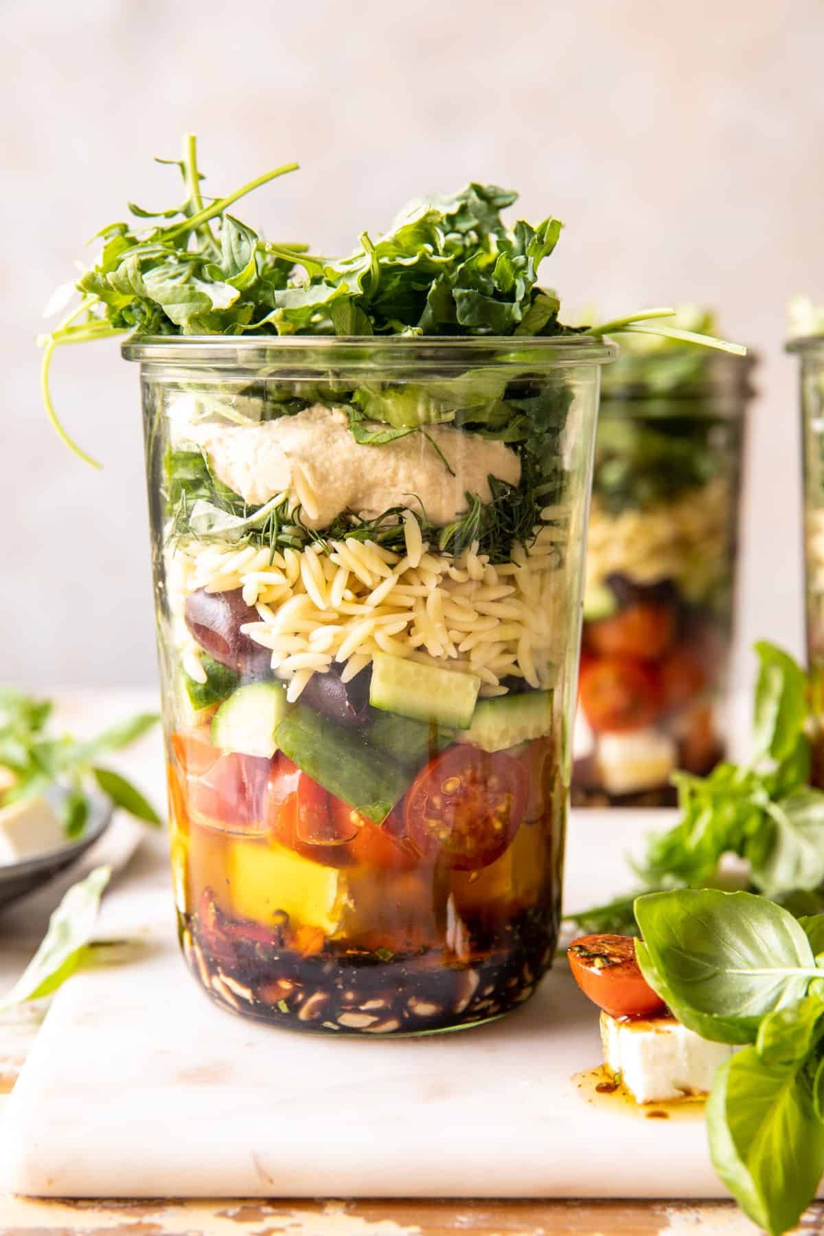 Orzo salad in mason jars for meal prep.