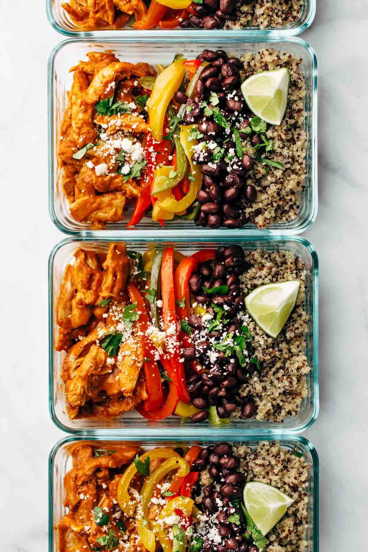 Chicken, peppers, beans, and quinoa in glass meal prep containers.