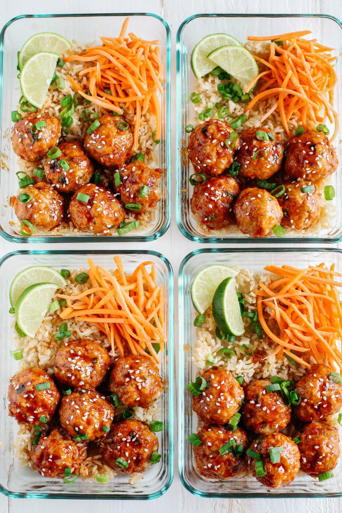 Meatballs in four glass meal prep containers with carrots and zucchini noodles.