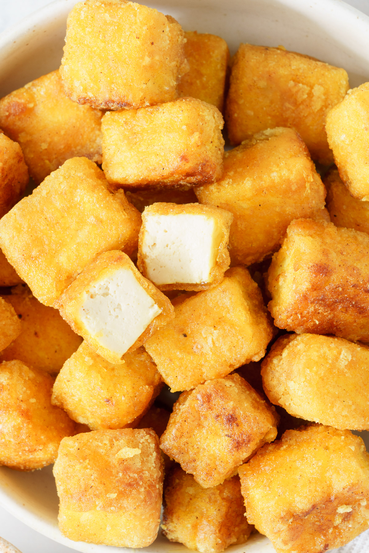 Close up of a bowl filled with crispy fried tofu.