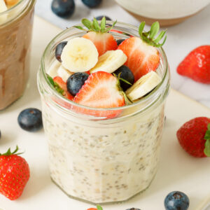 A jar of overnight oats topped with fresh fruits.