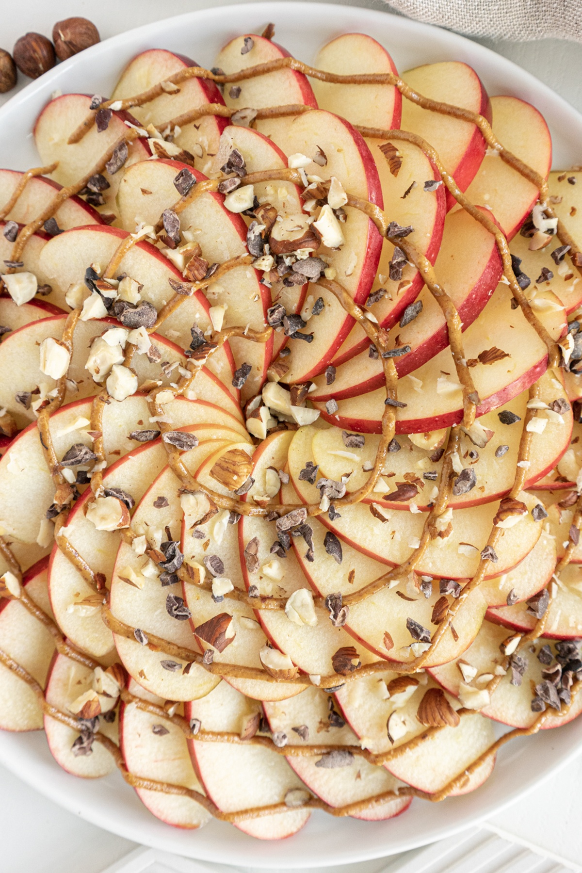 Apple nachos on a plate sprinkled with toppings.