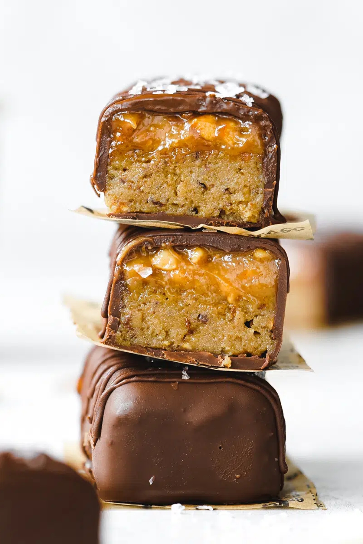 Chocolate peanut butter protein bars on a stack pile.