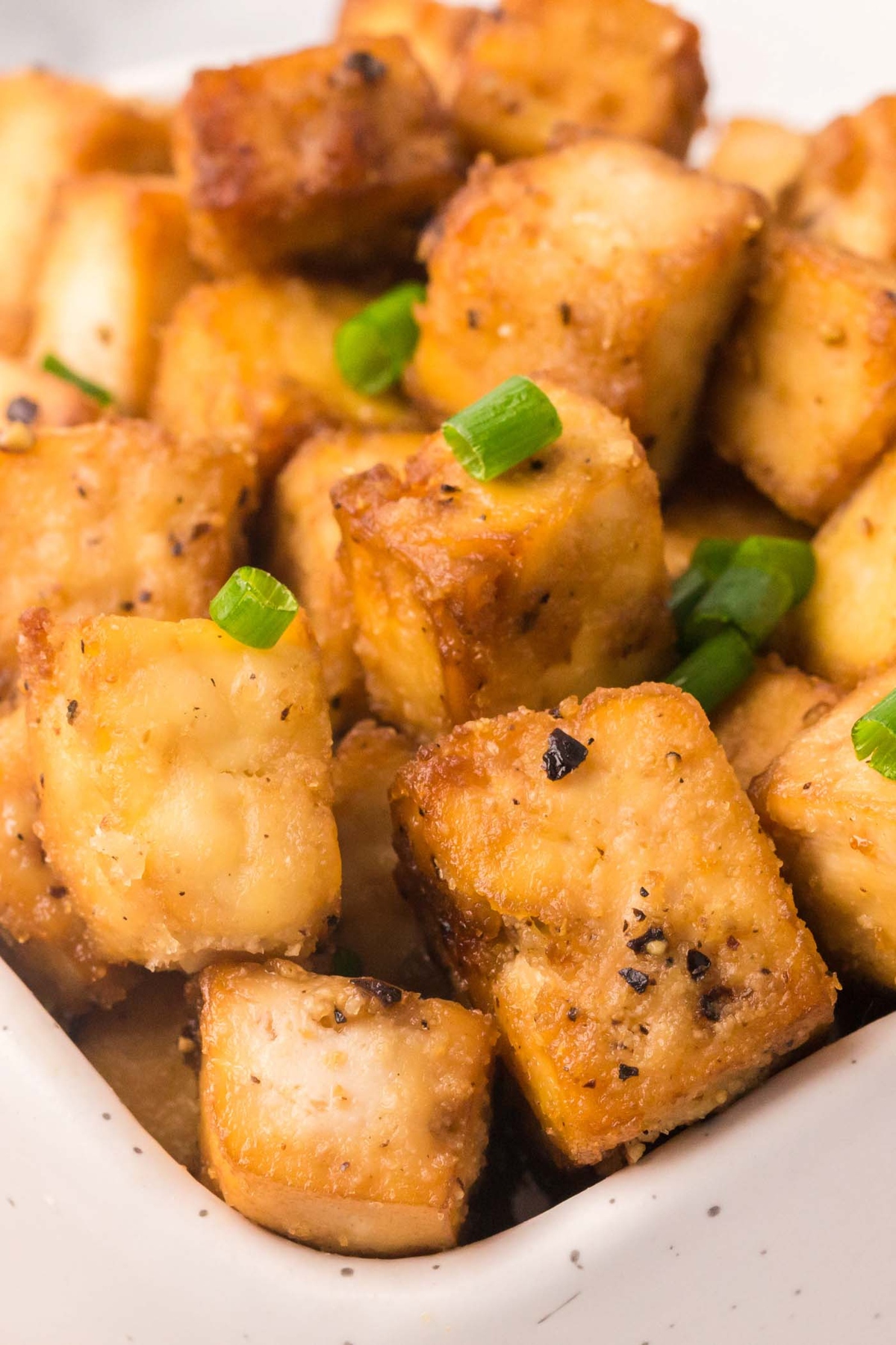 Crispy baked garlic black pepper tofu sprinkled with spring onions.