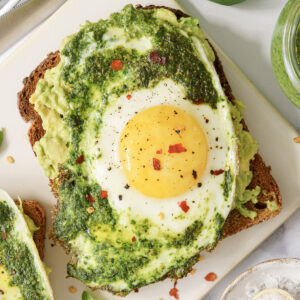 A single slice of bread with mashed potato topped with pesto egg.