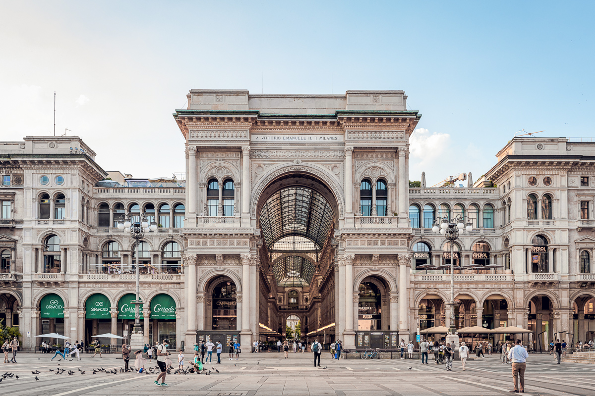 People in Piazza Duomo in Milan with Galleria Vittorio Emanuele II in the background.