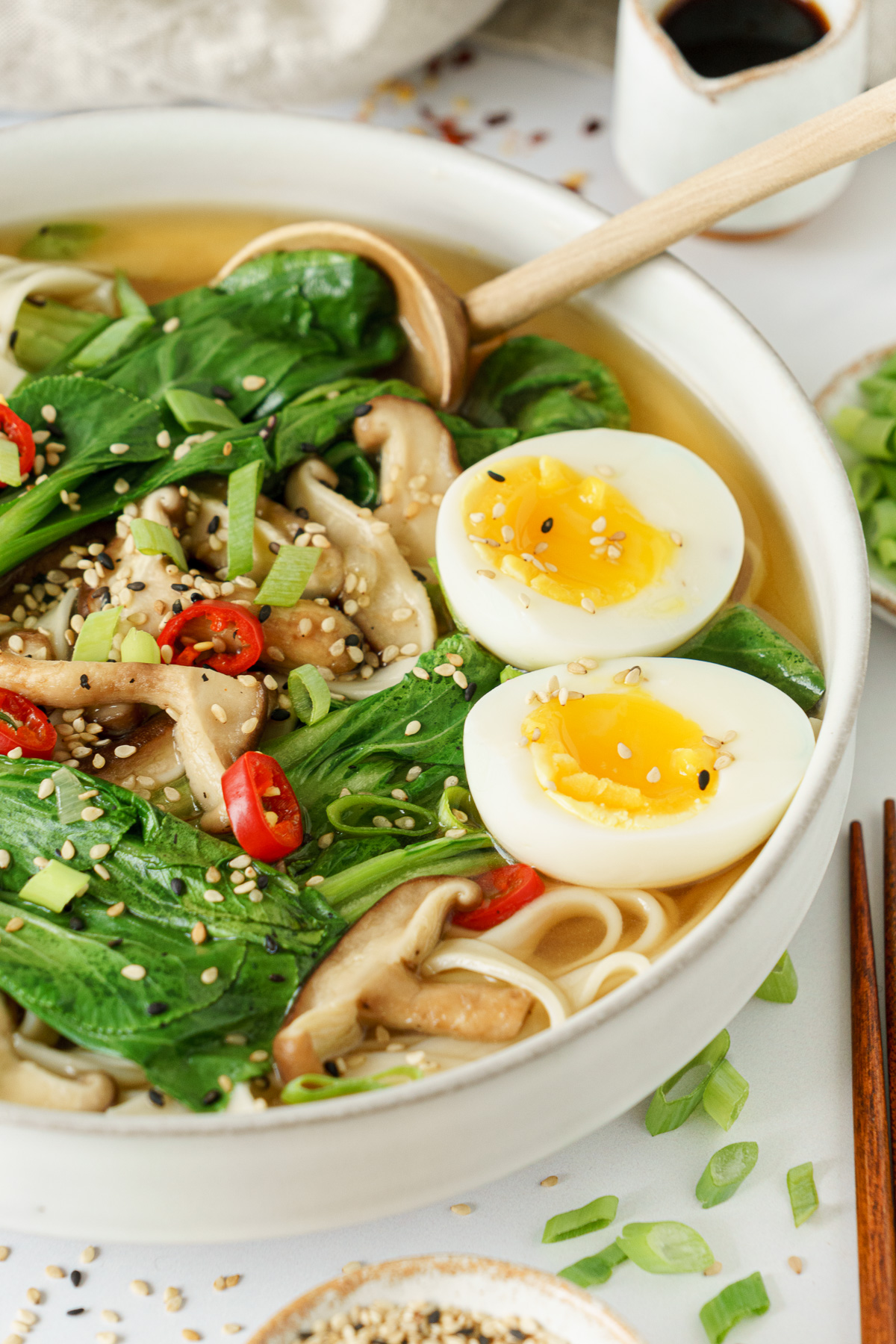 A half porton of a bowl full of bok choy soup.