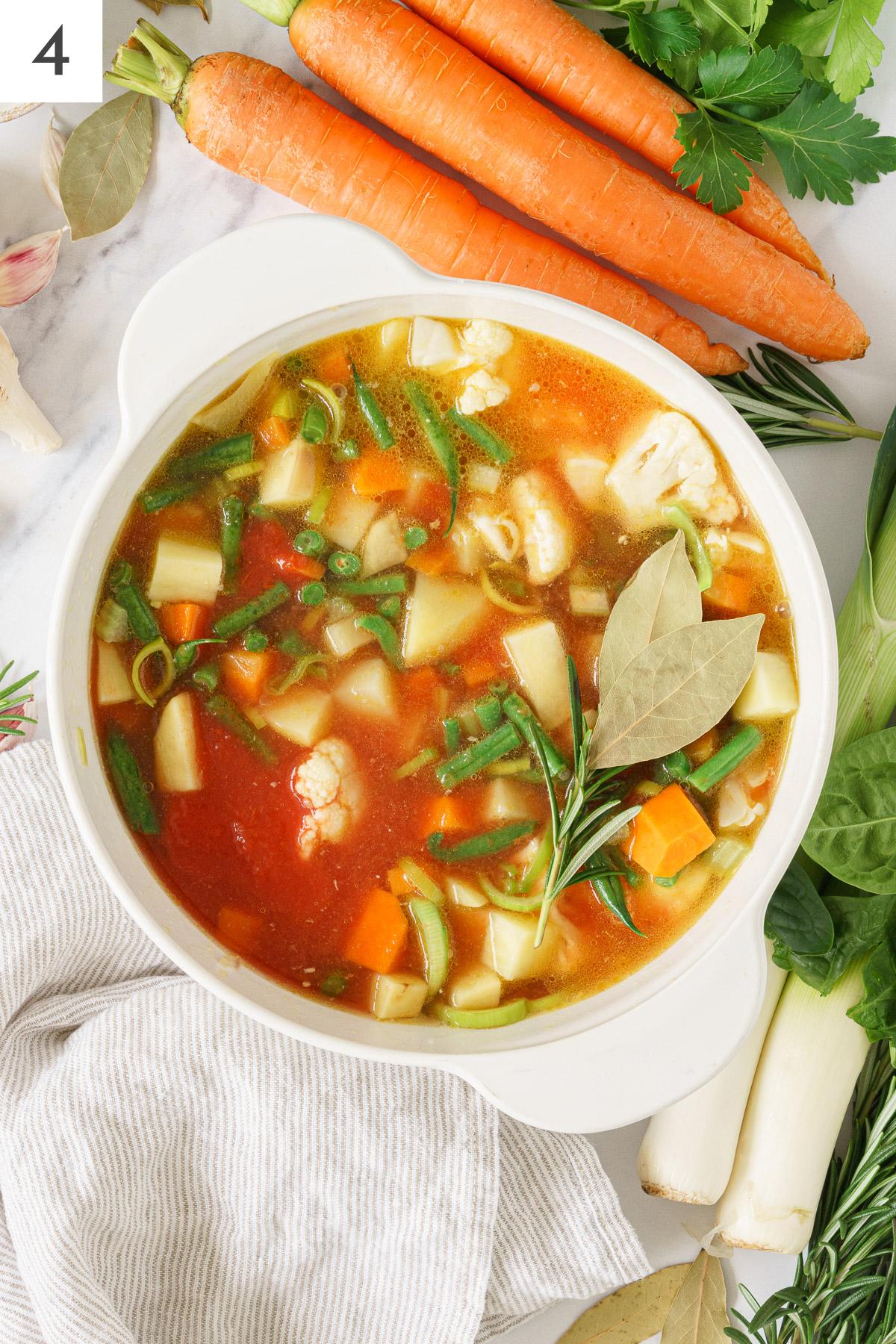 Italian minestrone soup ingredients boiling in a pot.