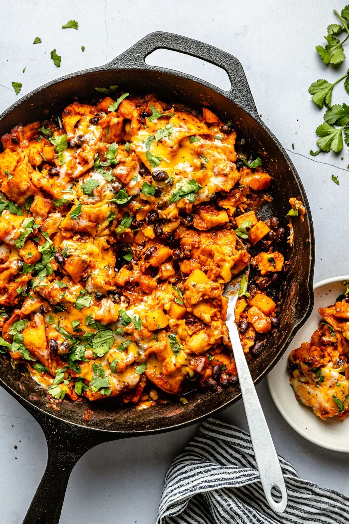 Butternut squash and black bean enchilada skillet in a wok.