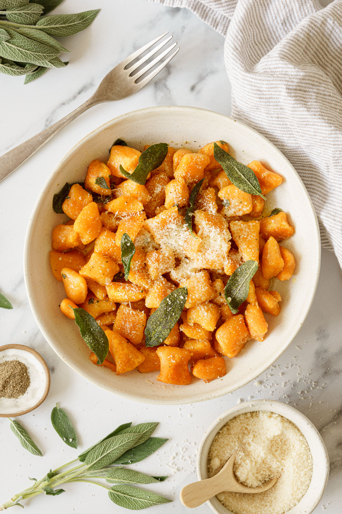 A plate of sweet potato gnocchi sprinkled with parmesan cheese.