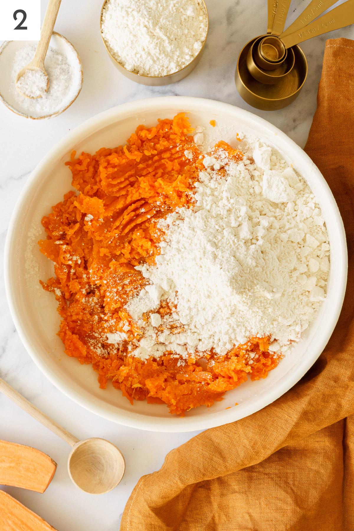 Mashed sweet potatoes mix with flour on a bowl.