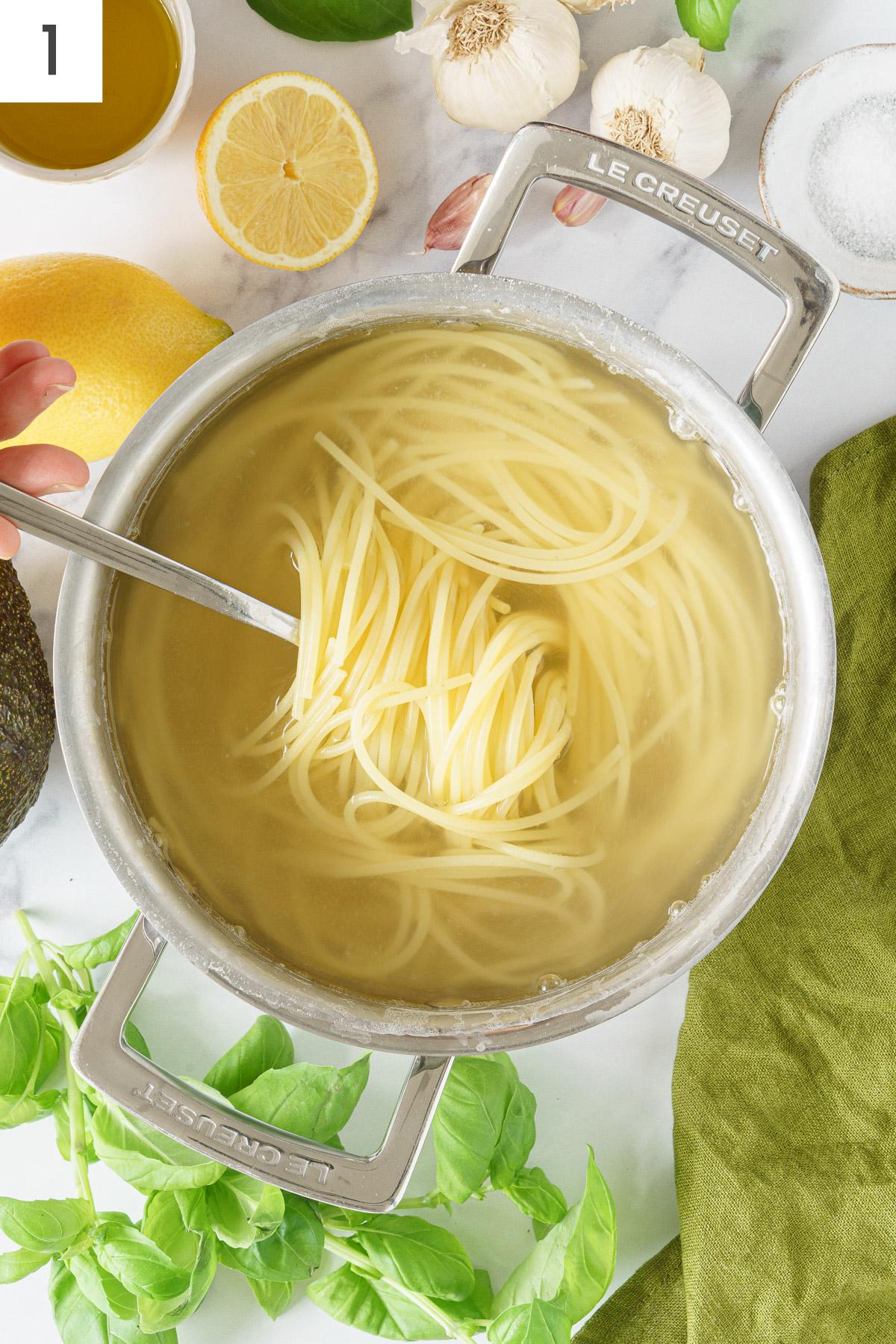 A pot with pasta and water to cook.