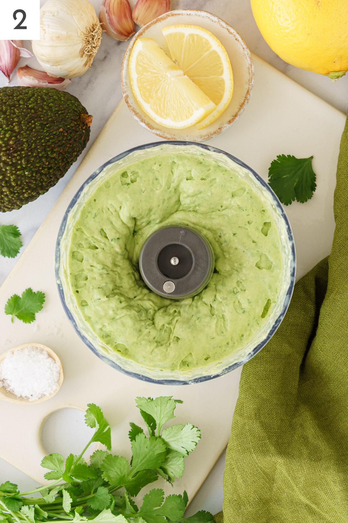 Blended avocado sauce in a food processor.