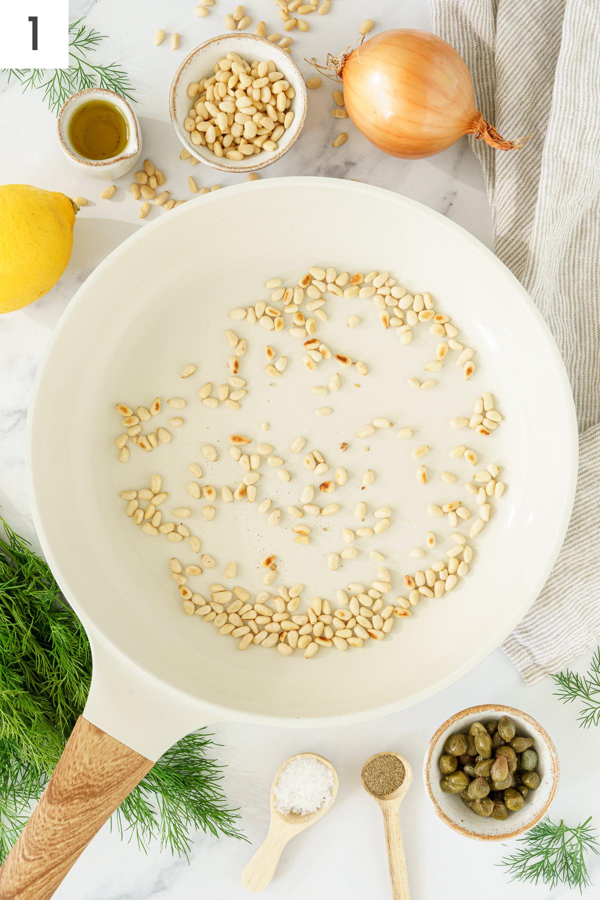 Toast pine nuts in a pan.