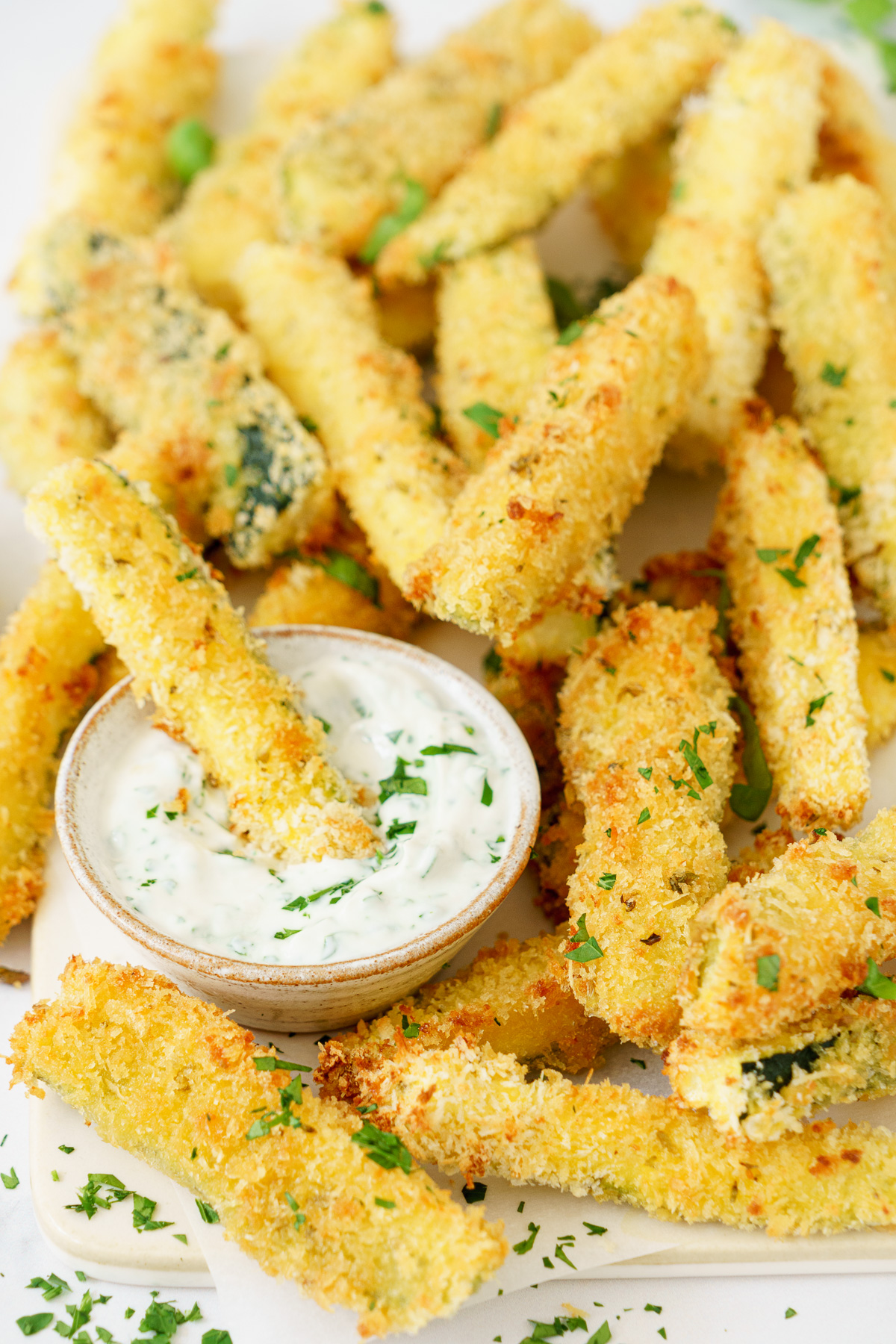 Delicious baked zucchini sticks with dipping sauce on the side.