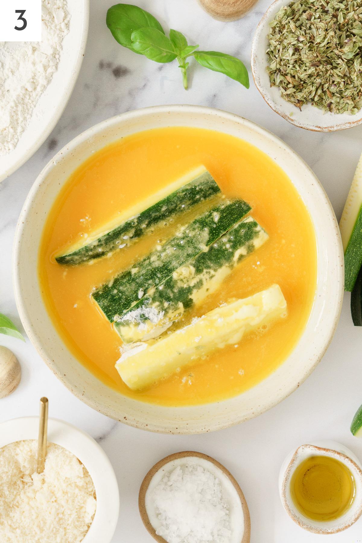 Flour coated zucchini sticks dipped in beaten eggs.