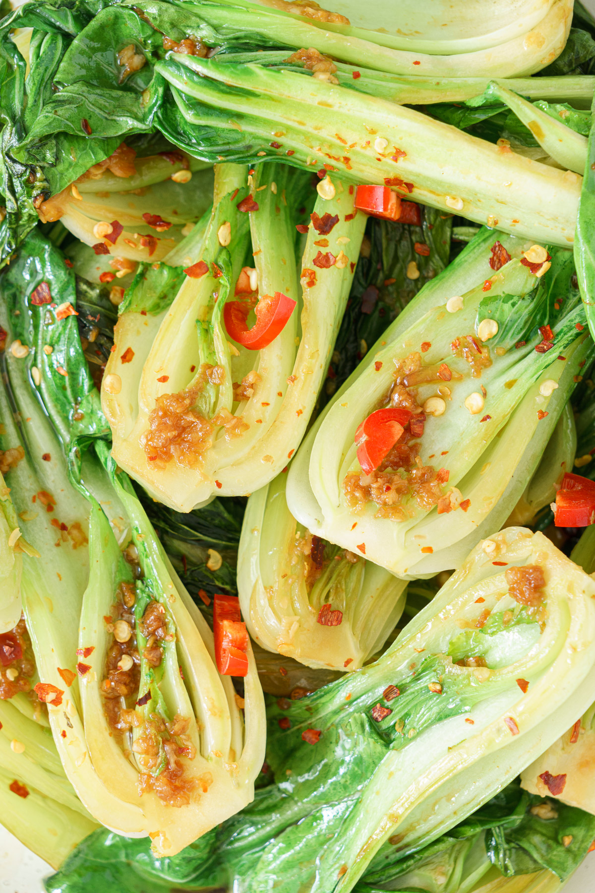 Bok choy topped with chili flakes and sautéed chopped garlic.